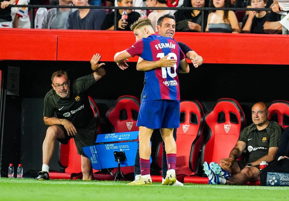 Fermín López abraza a Xavi tras su gol al Sevilla.