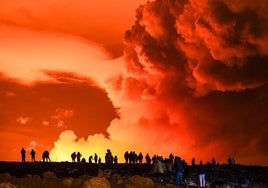 Un grupo de vecinos de Grindavik observa la erupción.