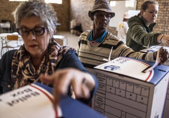 Votantes depositan su papeleta en un colegio electoral de Hopetwon.