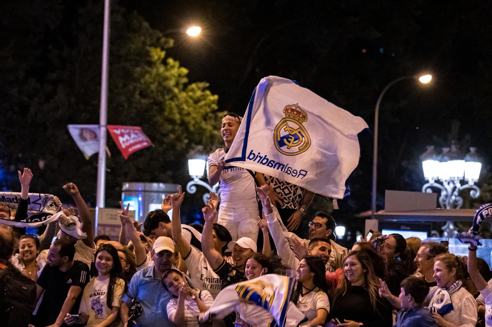 Una aficionada ondea una bandera del Real Madrid.