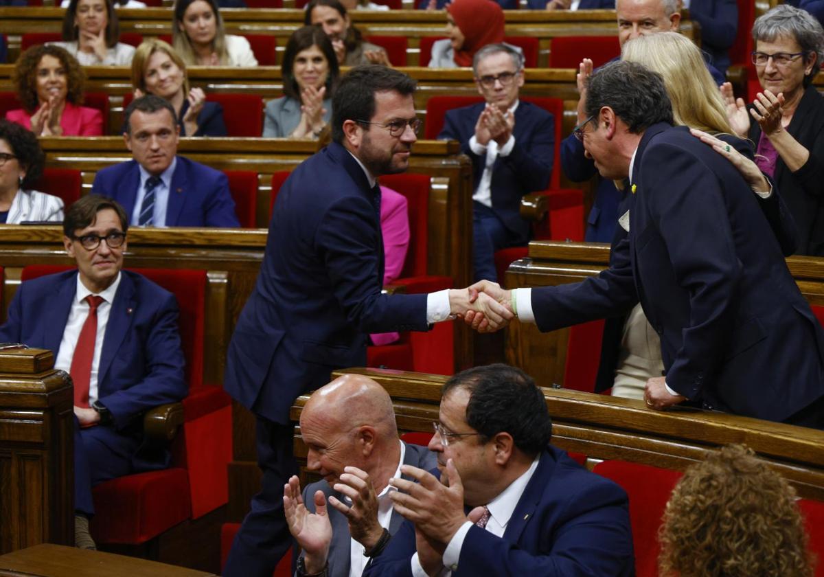 El nuevo presidente del Parlament, Josep Rull, recibe el saludo del jefe en funciones del Govern, Pere Aragonès, con el socialista Illa sentado en su escaño.