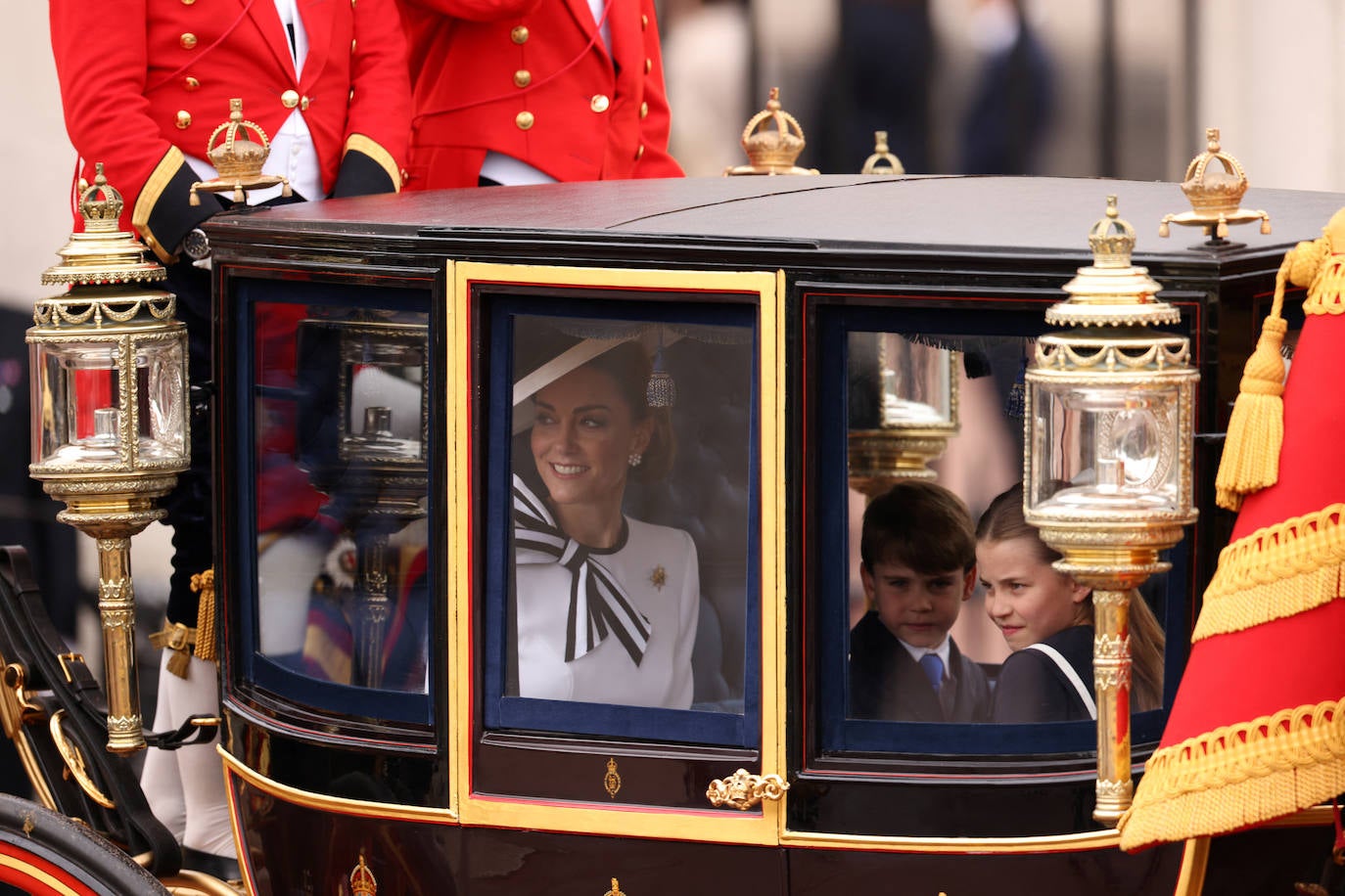 Kate Middleton, sonriente en un carreuaje junto a sus hijos.