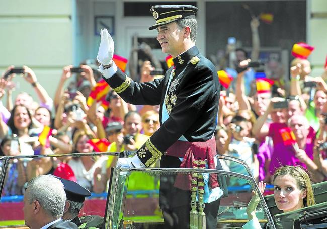 Don Felipe, convertido ya en Rey,saluda junto a la reina Letizia a quienes aquel 19 de junio de 2014 se echaron a las calles de Madrid a aclamarle.