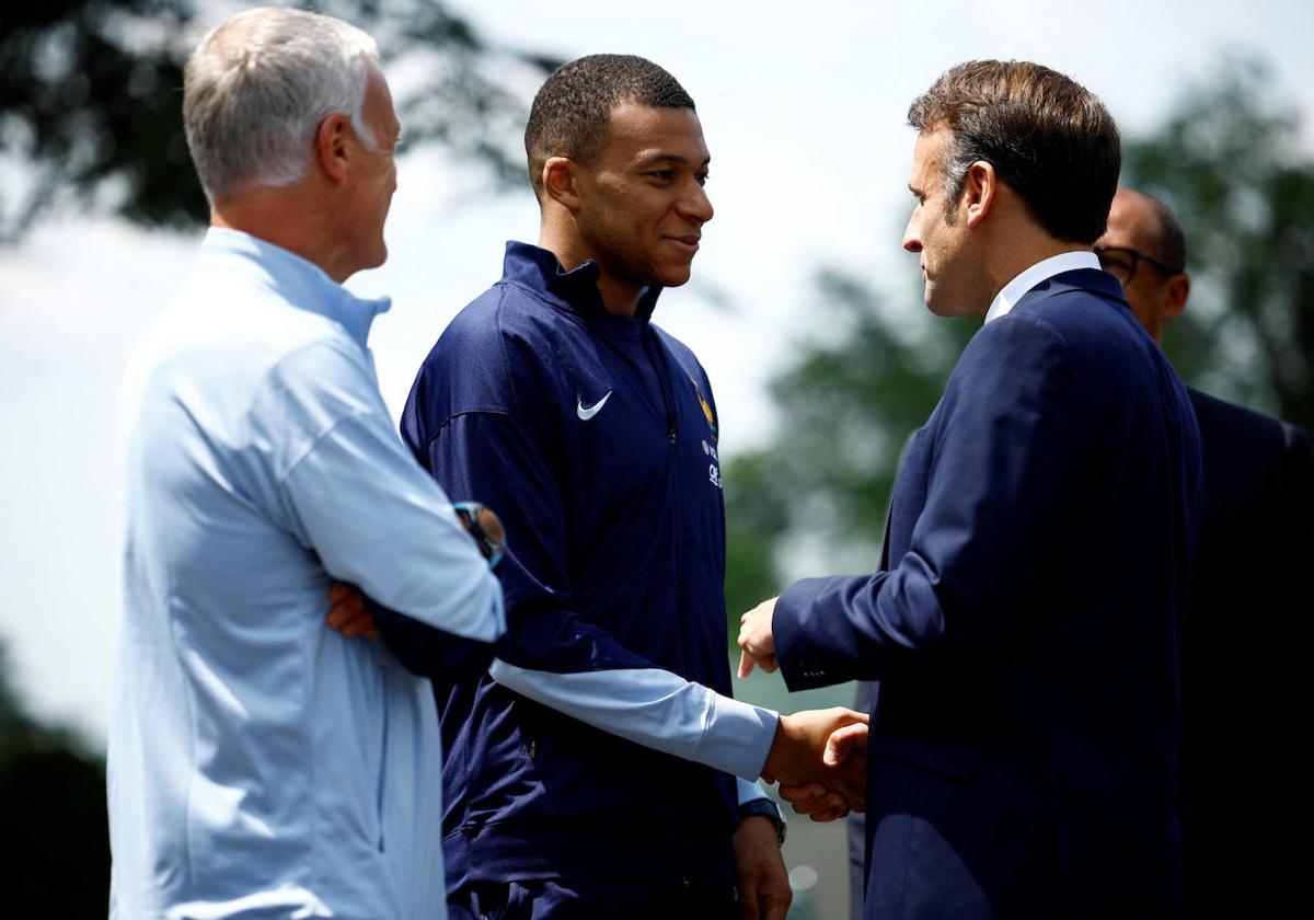 El presidente francés, Emmanuel Macron, le da la mano al futbolista francés Kylian Mbappe, en un encuentro previo a la Eurocopa.