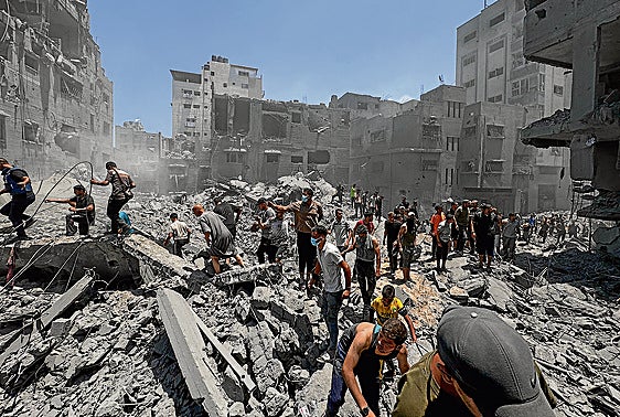 Gazatíes busca víctimas bajo los escombros del campo de refugiados de Al Shati.
