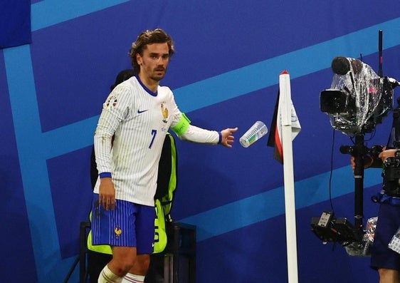 Antoine Griezmann retira un vaso de cerveza al ir a lanzar un córner.