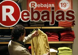 Un hombre busca una prenda durante las rebajas.