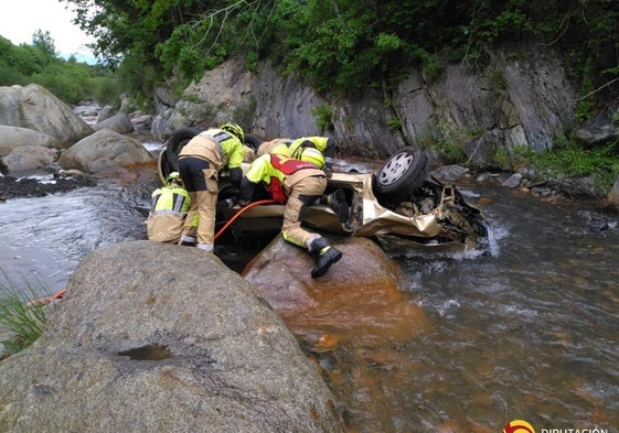 Los bomberos trabajan en el coche siniestrado.