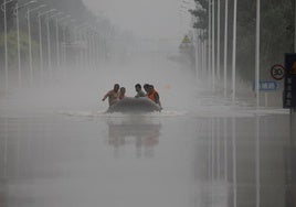 Vecinos de la provincia de Hubei son trasladados en bote por una carretera inundada.