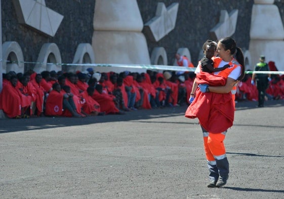 Una integrante de Cruz Roja lleva en brazos a un bebé tras el desembarco una patera en la isla de El Hierro.