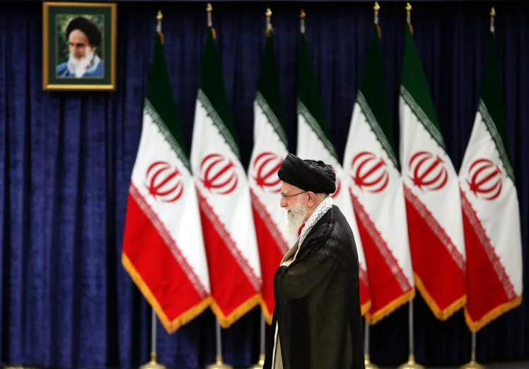 Ali Khamenei, in front of a portrait of Ali Khamenei.