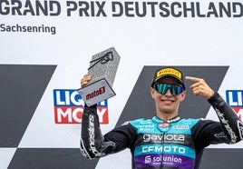 David Alonso con el trofeo y sonriente celebrando el primer puesto en el podio del GP de Sachsenring.