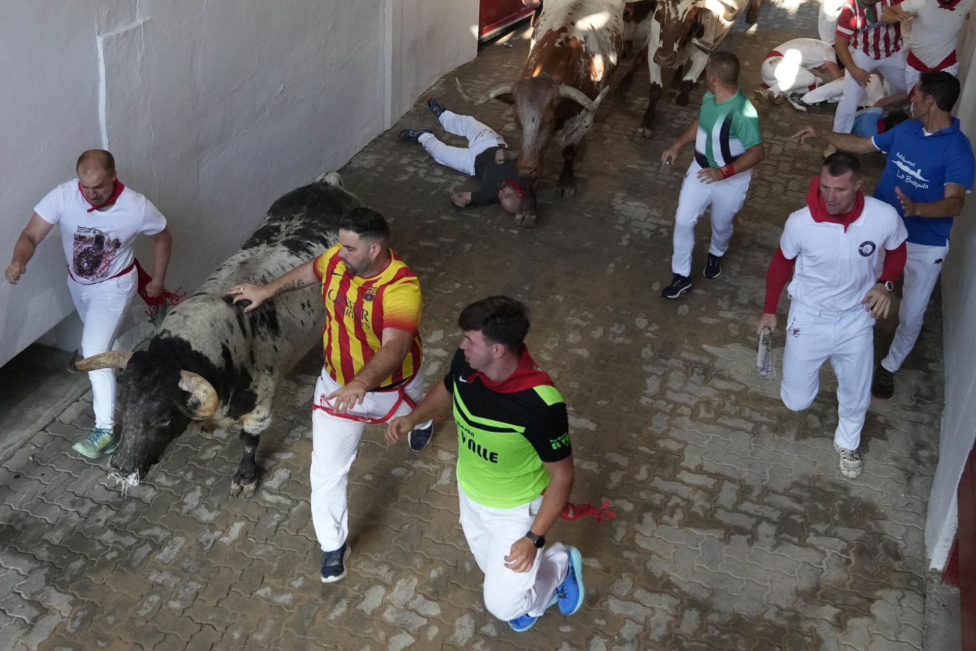 Varios mozos son perseguidos a la entrada de la plaza de toros.