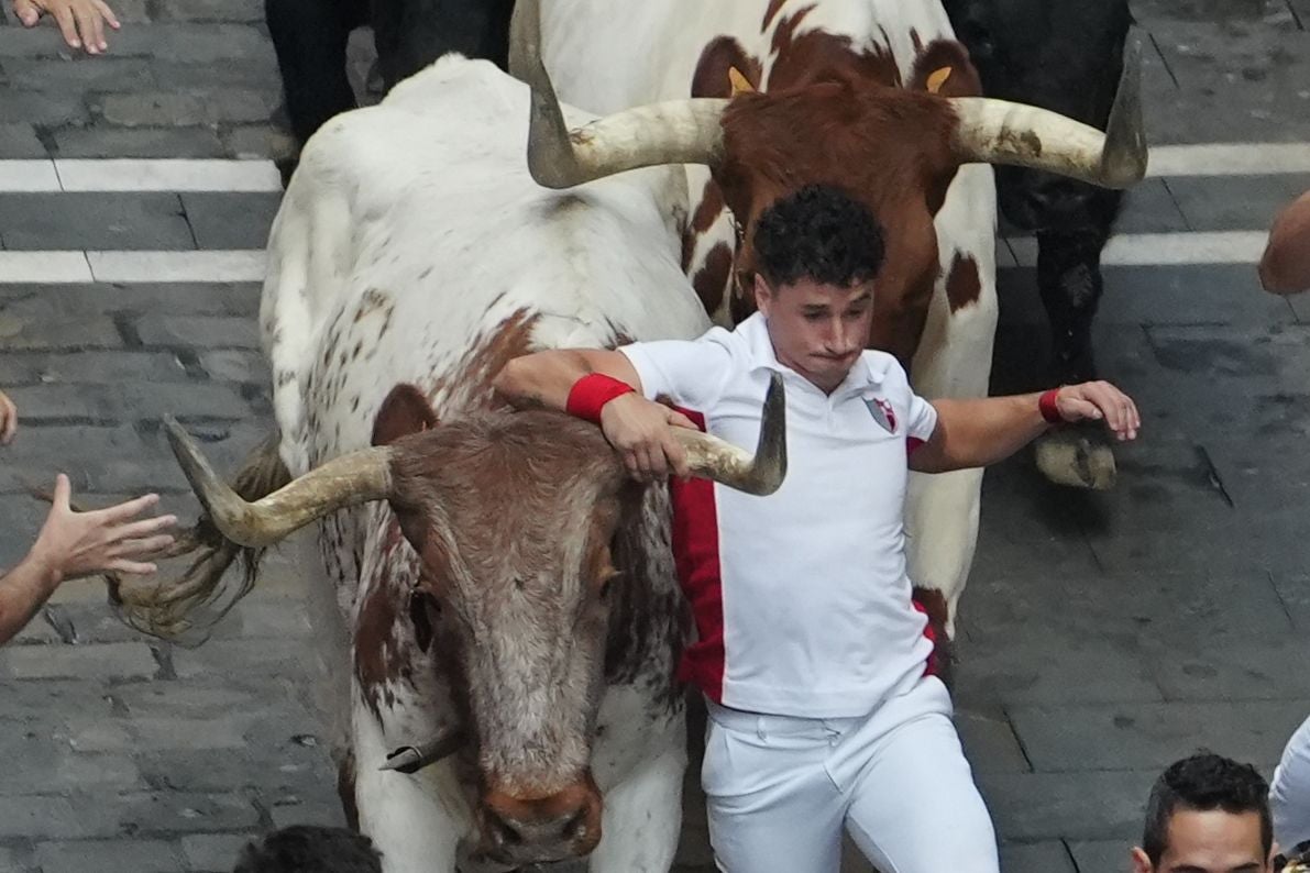 Los toros de la ganadería de Fuente Ymbro a su paso por la calle de la Estafeta en el cuarto encierro de los Sanfermines.