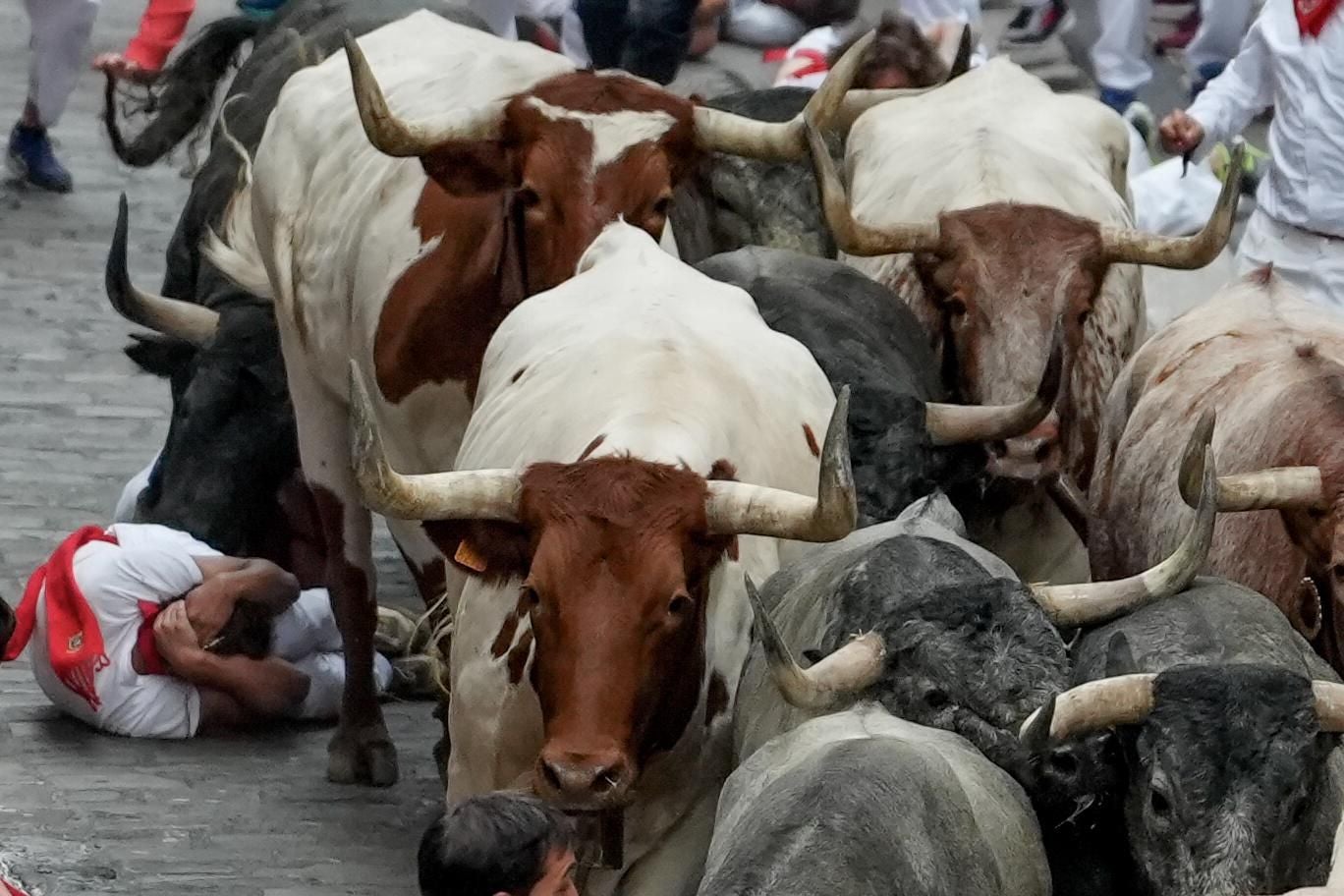 Un mozo cae delante de los toros y la manada le pasa por encima.