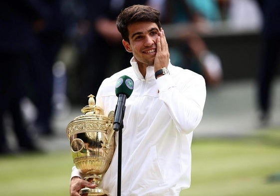 Carlos Alcaraz habla con el trofeo de campeón de Wimbledon.