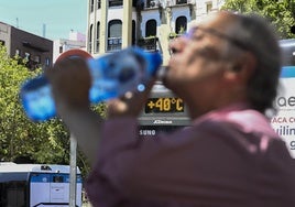 Una persona bebe agua en el centro de Madrid.