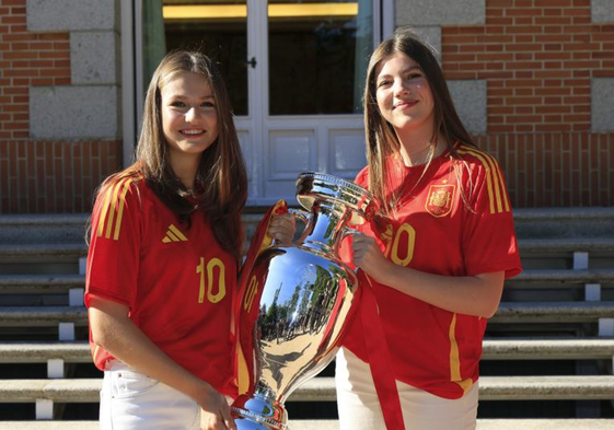 La princesa Leonor y la infanta Sofía (d) posan con el trofeo en la recepción a la selección española