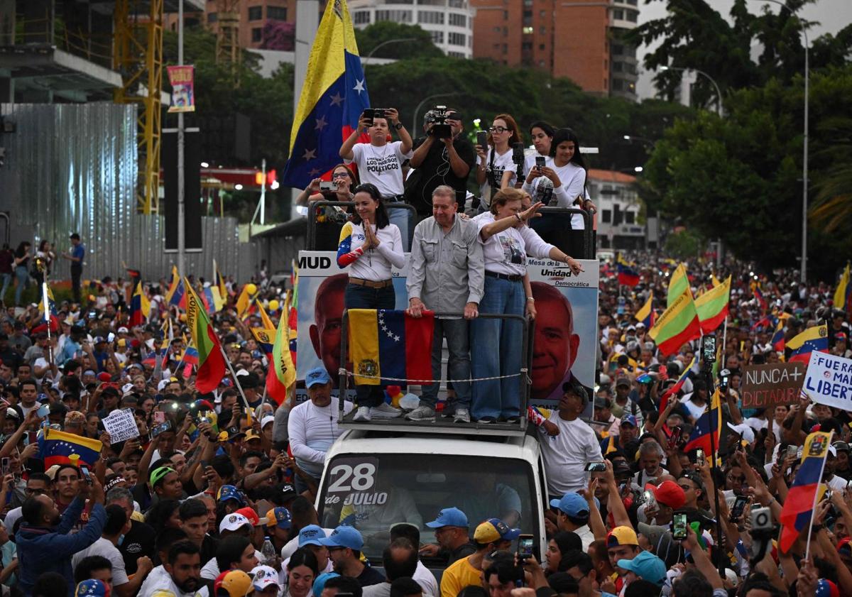 Imagen principal - Edmundo González, acompañado de su esposa, Mercedes, y María Corina, saludan a sus seguidores a bordo de un vehículo.