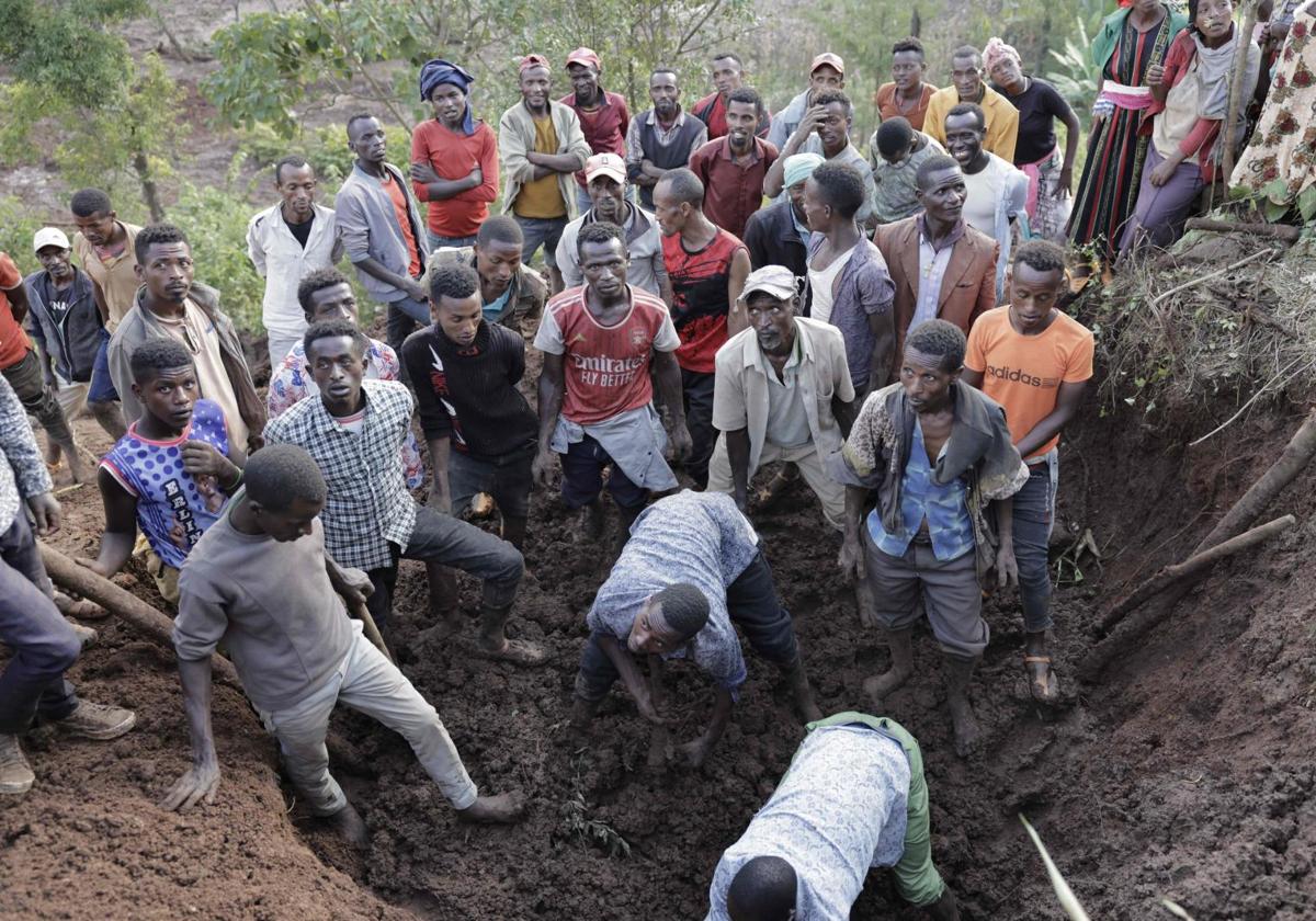 Residentes y voluntarios cavan en el barro en busca de supervivientes en el lugar de un deslizamiento de tierra en Gofa.