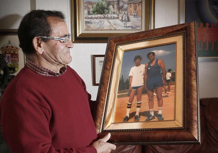 Mariano Haro en su casa de Becerril de Campos mira una foto con el entonces Príncipe Felipe, en 1982, ya que fue su instructor en un campamento de atletismo en Palma de Mallorca.