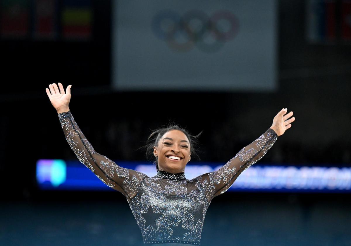 Simone Biles, sonriendo después de ejecutar el ejercicio de barras en París 2024