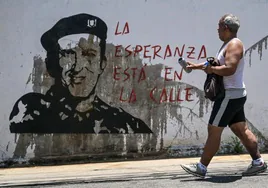 La imagen de Hugo Chávez en un muro de Caracas aparece con una pintada que convoca a manifestarse en las calles.