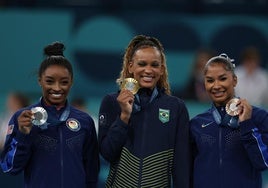 Rebeca Andrade, entre Simone Biles y Jordan Chiles tras la final de suelo.