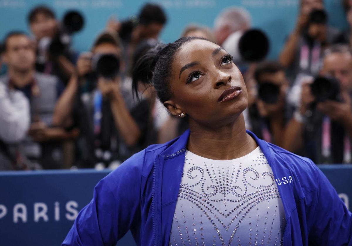 Simones Biles, muy seria, observando las puntuaciones tras su mal ejercicio.