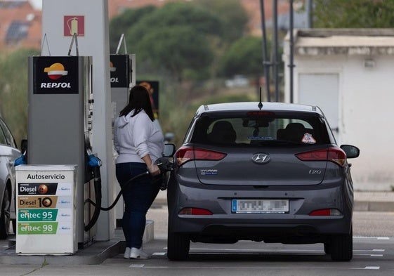 Una señora reposta gasolina.