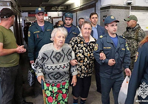 Personal del Ministerio ruso de Emergencias acompañan a vecinos de Kursk en su evacuación en plena ofensiva ucraniana.