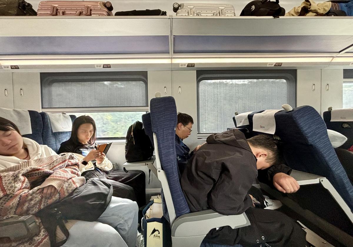 Pasajeros en tren bala hacia Kunming. Algunos aprovechan el trayecto para leer o para dormir en posiciones imposibles.