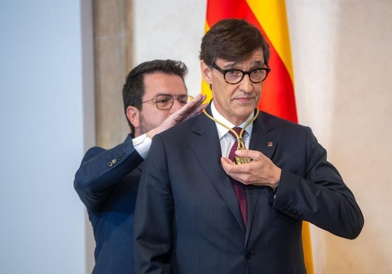 Aragonès coloca a Illa la medalla de la presidencia.