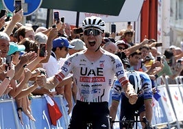Hirschi, exultante, celebra la victoria con Alaphilippe en segundo plano.