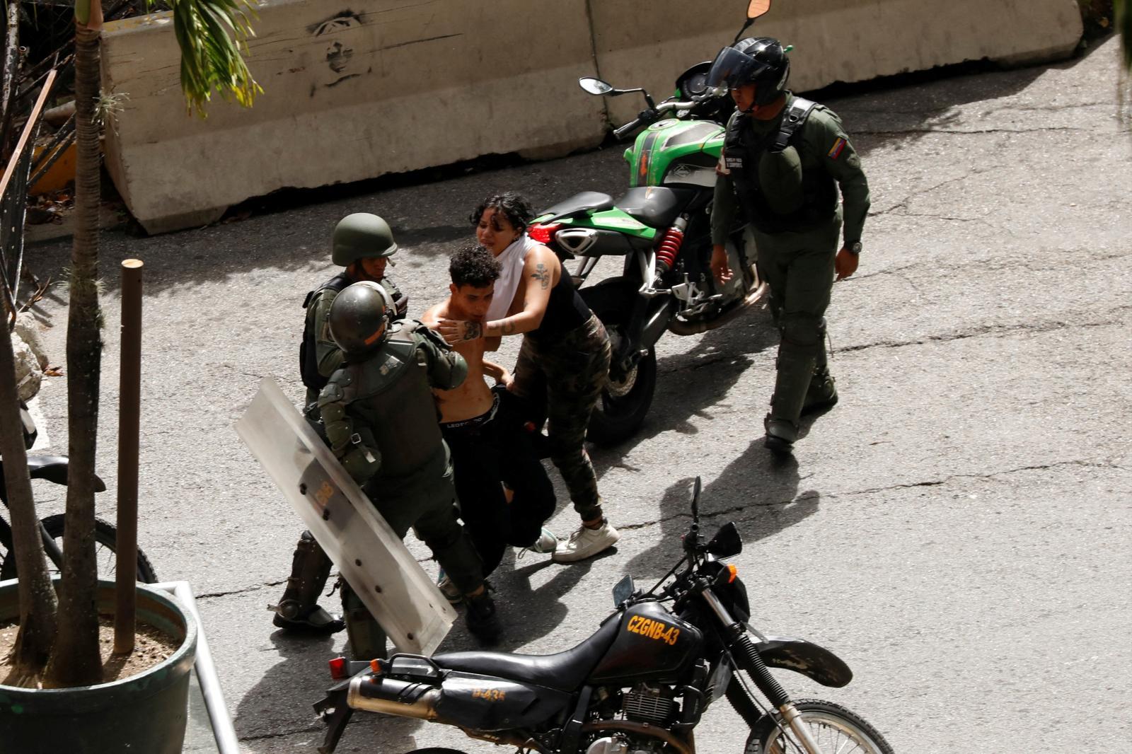 La Guardia Nacional detiene a un joven manifestante crítico con la victoria del chavismo.