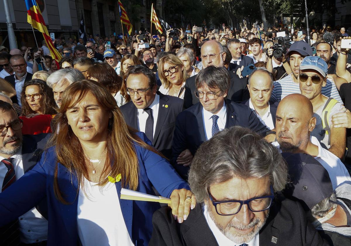 Carles Puigdemont avanza por las calles de Barcelona rodeado de los dirigentes de Junts el pasado 8 de agosto.