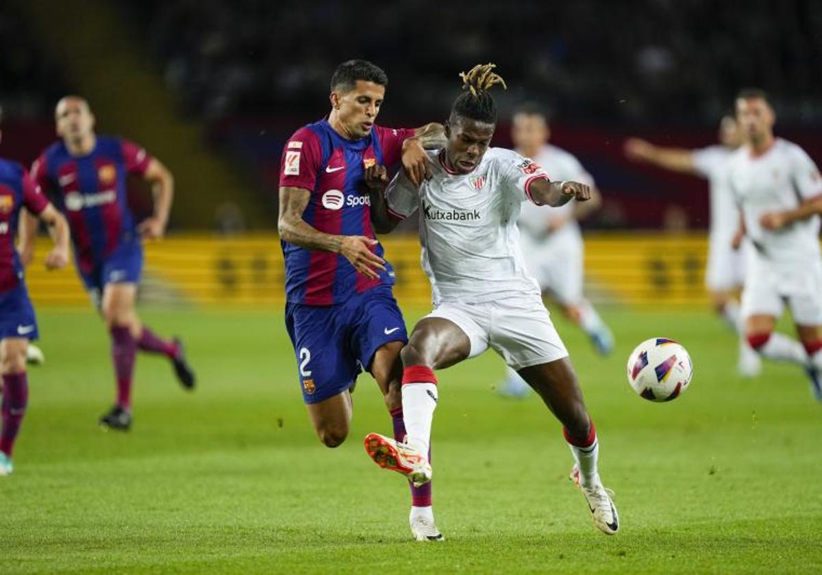 Nico Williams, marcado por Joao Cancelo, durante un partido de la pasada temporada en Montjuic.