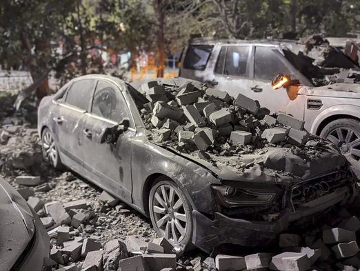 Un coche destrozado bajo los escombros tras uno de los ataques con drones.