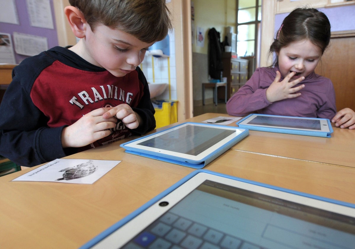 Dos escolares hacen los ejercicios con sus tabletas.