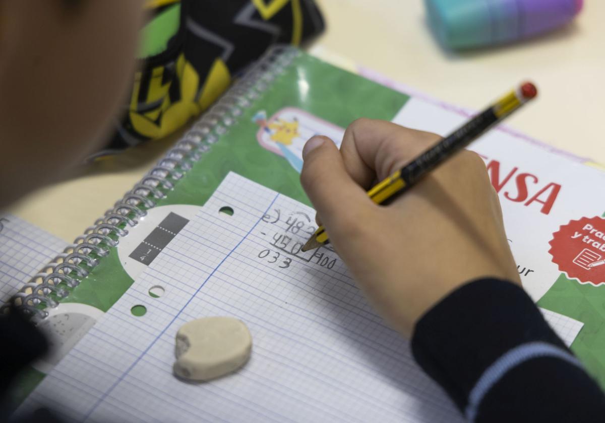 Un alumno escribe en su cuaderno.