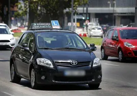 Imagen de un coche de autoescuela que circula por Valencia.