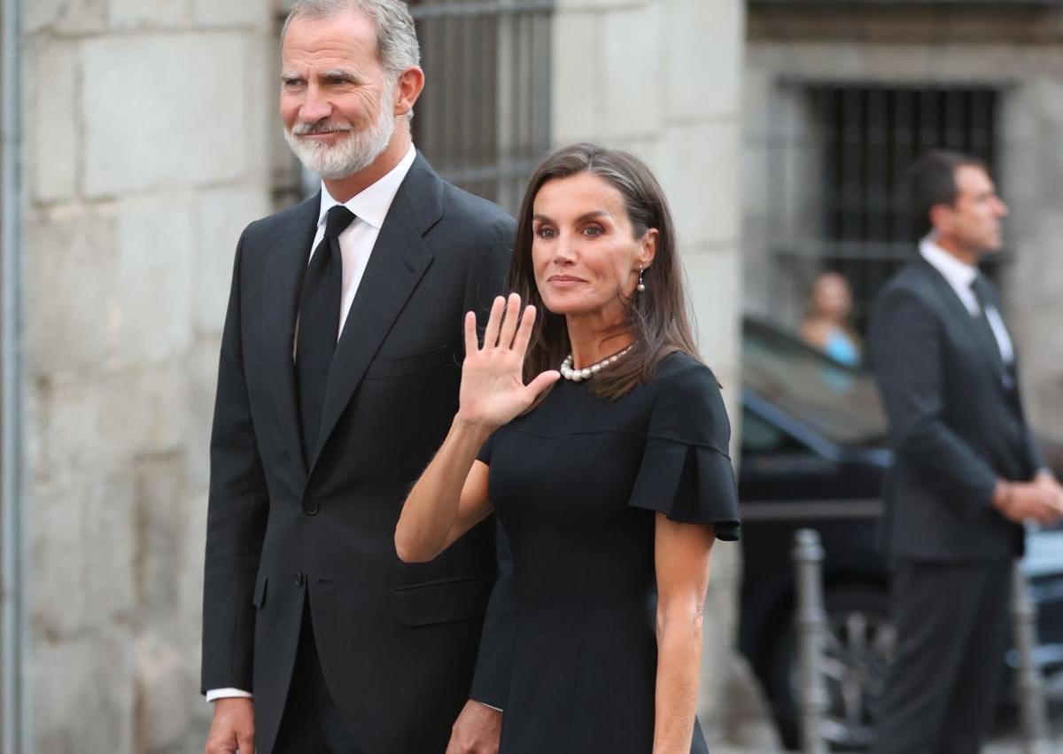 Imagen secundaria 1 - En la imagen superior, los Reyes saludan asaludan a Beltrán, Bruno y Simoneta Gómez-Acebo a su llegada a la catedral donde se ha celebrado el funeral; debajo, Don Felipe y Doña Letizia saludan a los madrileños a los ciudadanos y a los medios presentes; por último, el monarca por la mañana en el cementerio madrileño donde se enterraron las cenizas de su primo Juan Gómez-Acebo.