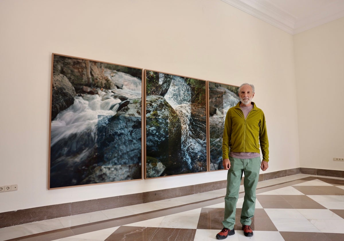 Javier Vallhonrat posa junto a un tríptico que forma parte de su exposición de fotografía.