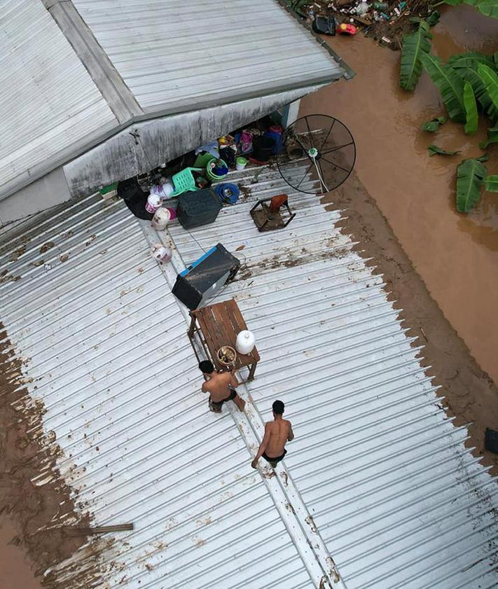 Imagen secundaria 2 - Equipos de salvamento trabajan en el rescate de supervivientes, algunos de los cuales han tenido que refugiarse en los tejados por las graves inundaciones del tifón 'Yagi'.