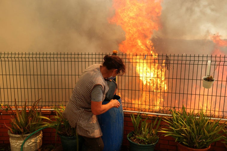 Una vecina de Vilarinho con el fuego a escasos metros de su vivienda.