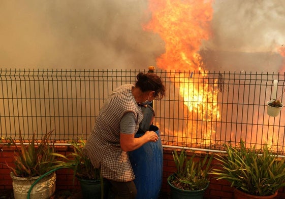 Una vecina de Vilarinho con el fuego a escasos metros de su vivienda.