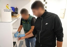 Un Guardia Civil toma la huella dactilar al detenido.