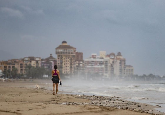 Una mujer pasea por la playa de La Patcona en Alboraya (Valencia).