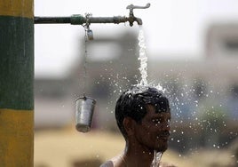 Un joven se refresca en la calle durante una ola de calor en India, uno de los países señalados en el informe.