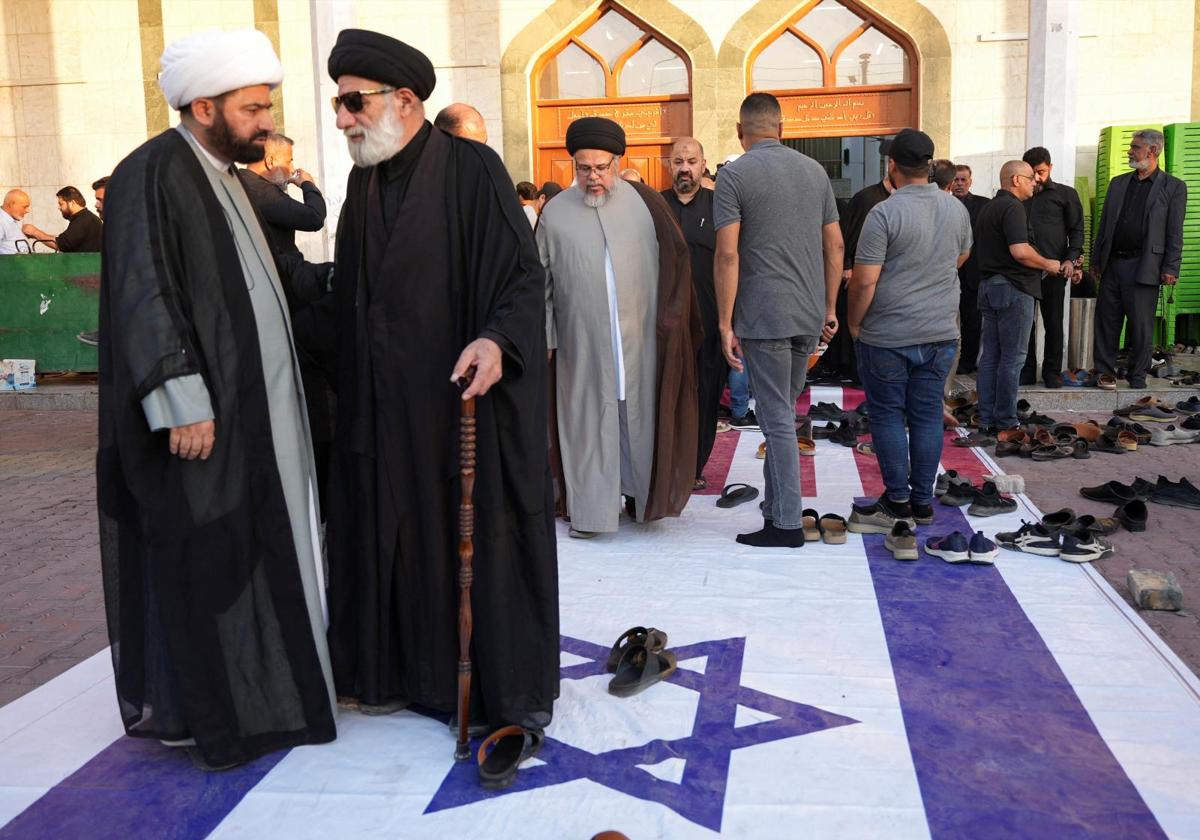 Clérigos iraquíes pisotean una bandera israelí durante un acto en Basora en recuerdo de Nasrala